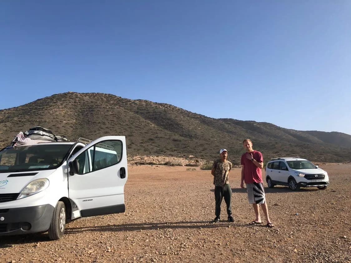 Surf travelers meeting beside vans on a southern Morocco coastal route